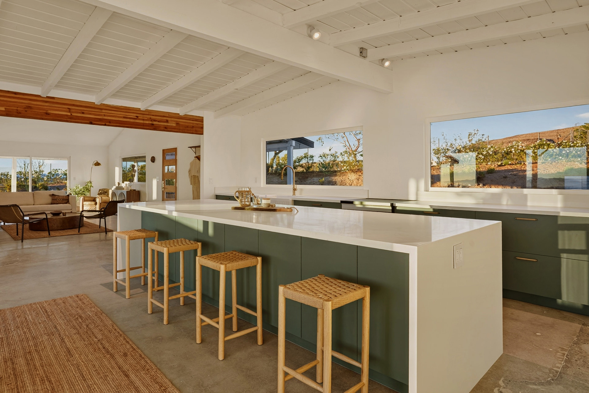 Chef's kitchen with green island, woven stools and picture windows